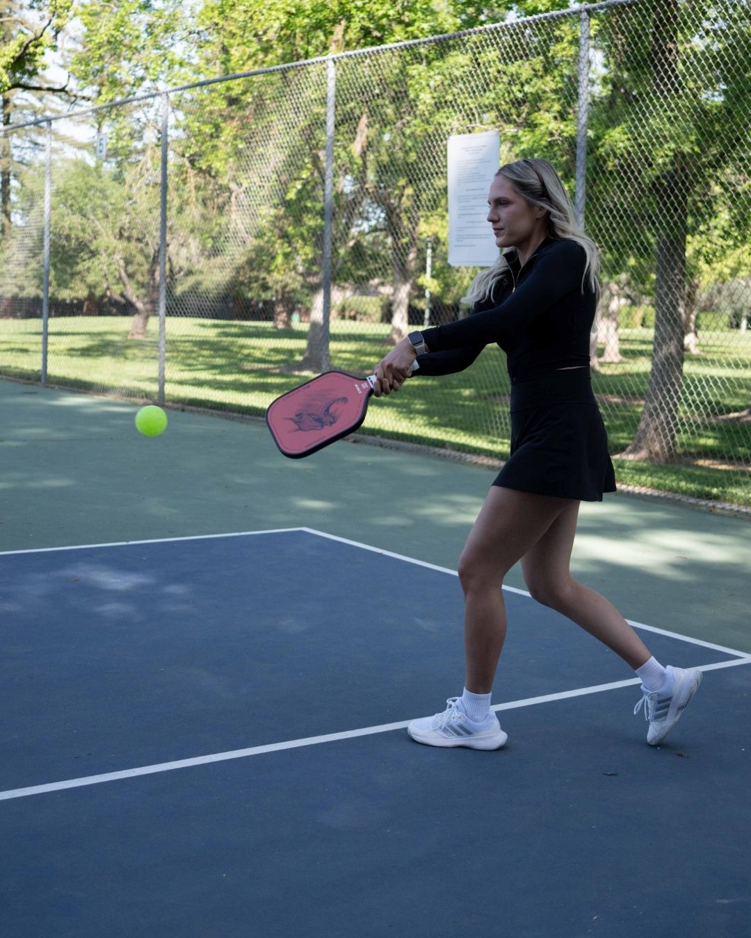 Woman playing pickleball with the Chupacabra paddle by Crew Pickleball, a 16mm kevlar weave paddle engineered for superior control on the court.